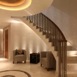 sweeping staircase with lights down to under lit seating area