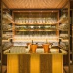 Backlighting to glass bottles in gold bar at Marylebone Hotel