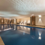 Luxurious swimming pool in chalet with uplights to walls