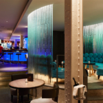 Seating area in hotel bar with blue light on curved glass wall