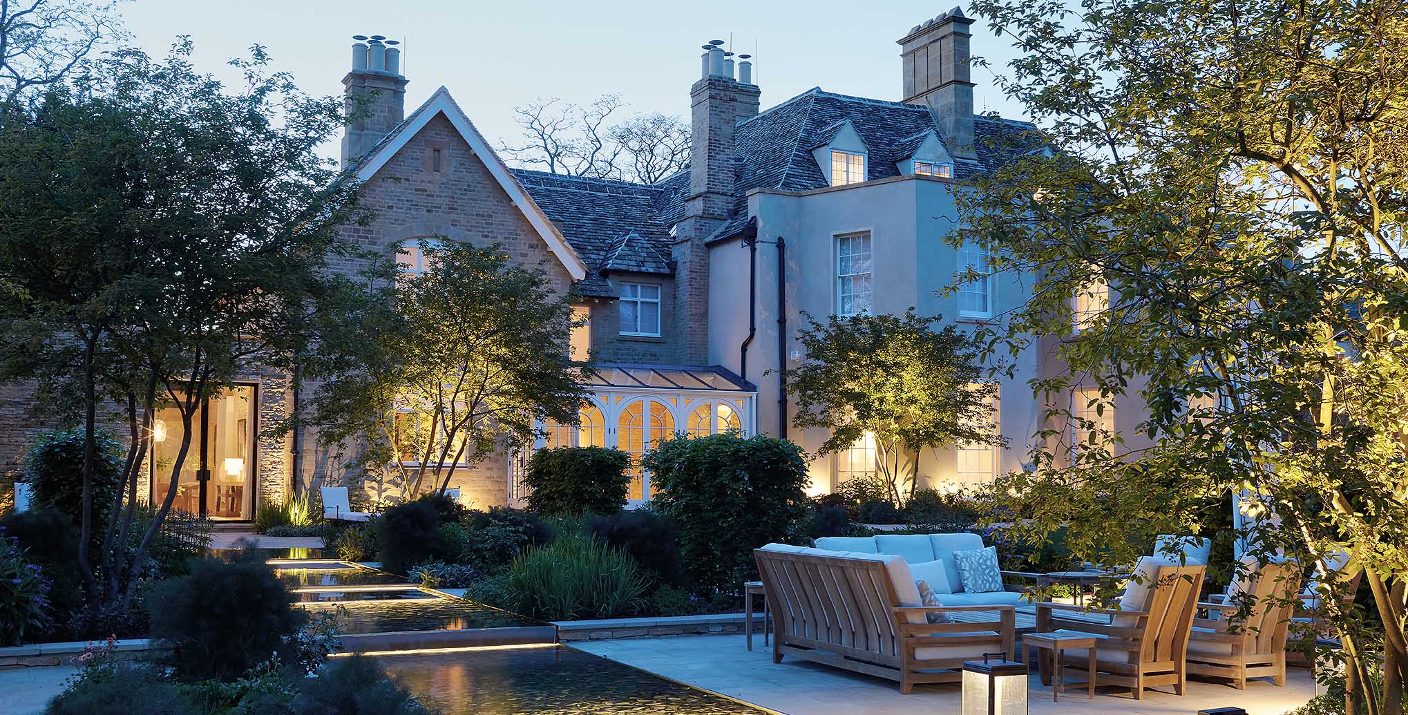 English Country Garden with water rills and uplit trees