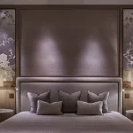 Luxurious bedroom with table lamps ether aside and downlights onto headrest