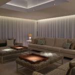 Living area with downlit curtains and pools of light over the two coffee tables