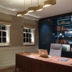 Home office with joinery unit lit with linear strip and uplighting to window reveals